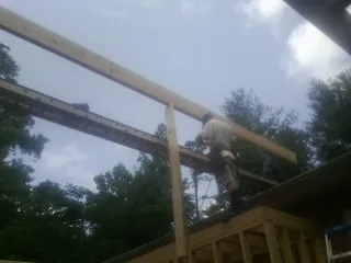 Carpenter setting a ridge beam over a new addition frame — Ice Dam Removal by Roofing Brothers in Plumtree