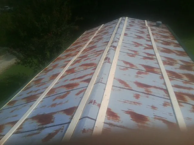 Rusted metal roof panels with new wood purlins before replacement — Storm Damage Roof Repair in Plumtree by Roofing Brothers